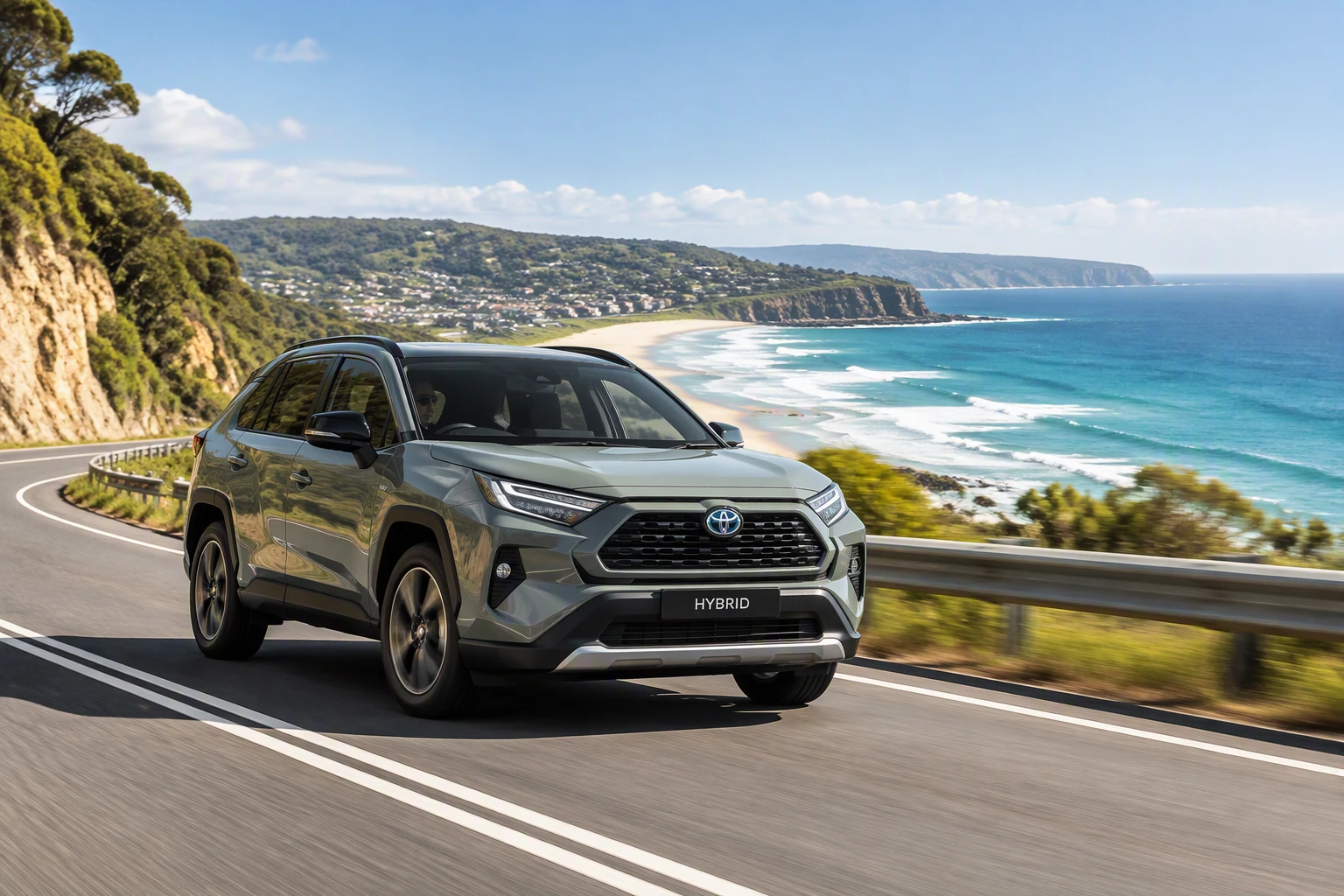 A hybrid SUV on a winding coastal road above a surf beach